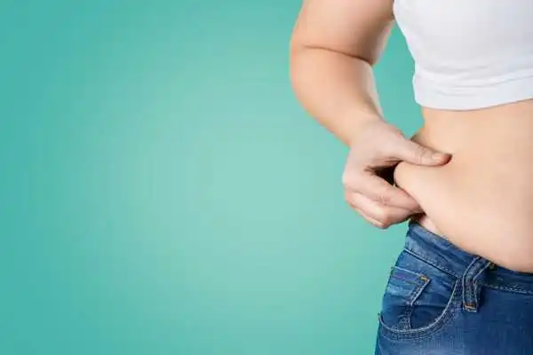 Image of woman pinching her love handles to show weight gain Higham Ferrers