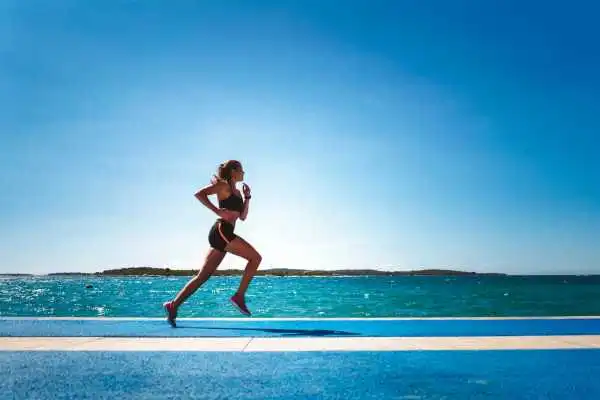 Woman running showing strong leg muscle Higham Ferrers